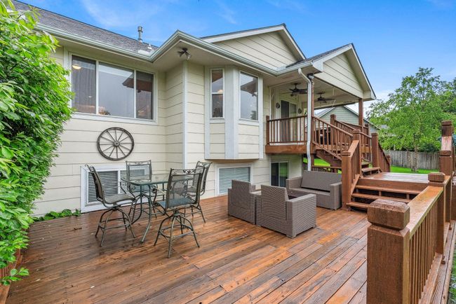 Wooden deck with stairs, a ceiling fan, outdoor dining space, and outdoor lounge area | Image 24