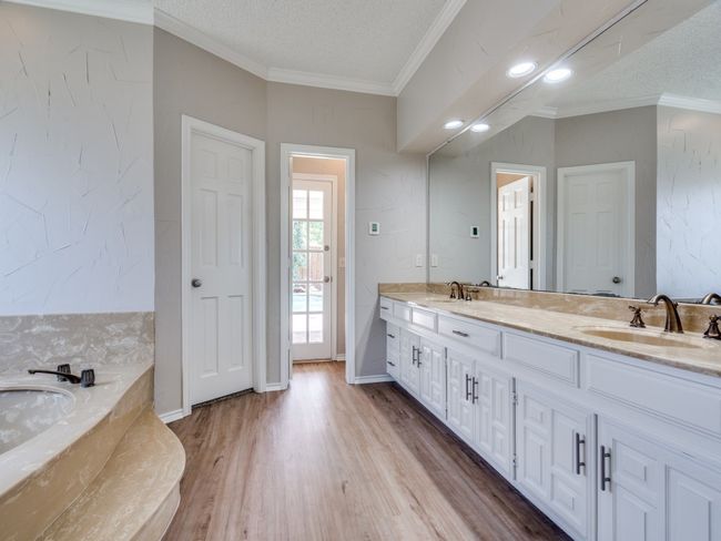 Primary bath has new luxury vinyl plank flooring and direct access to the pool. | Image 24