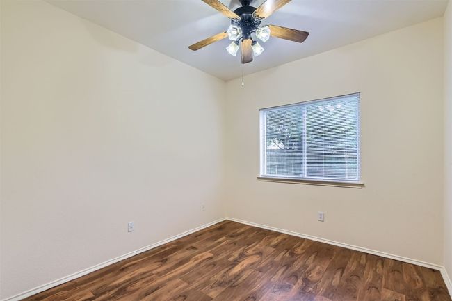 Spare room with baseboards, dark wood finished floors, and a ceiling fan | Image 19