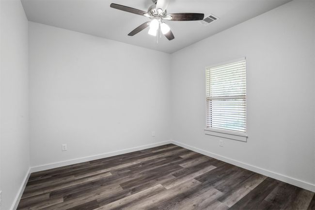 Spare room featuring dark wood-style floors and a ceiling fan | Image 7