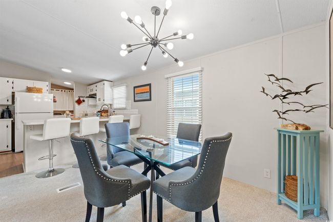 Dining room featuring a chandelier and light colored carpet | Image 5