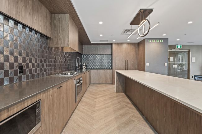 Kitchen with hanging light fixtures, modern cabinets, stainless steel appliances, backsplash, and recessed lighting | Image 30