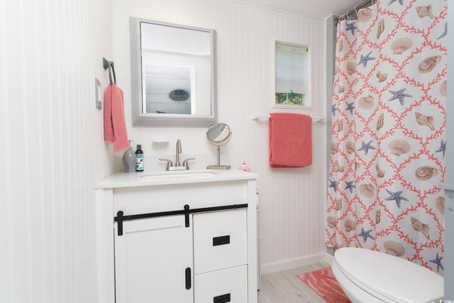 Bathroom featuring vanity, wood finished floors, toilet, a shower with curtain, and baseboards | Image 23