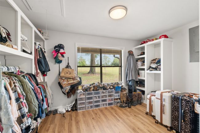 Spacious closet with attic access, wood finished floors, and electric panel | Image 20