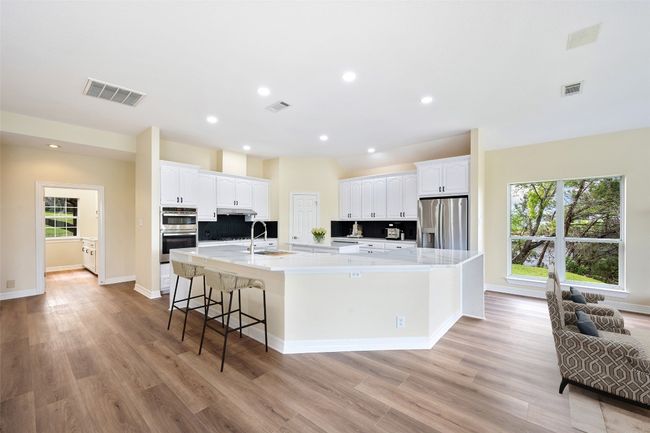 View of kitchen from den with doorway leading to laundry room. | Image 14