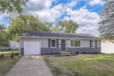 Single story home featuring a garage and a front lawn | Image 1