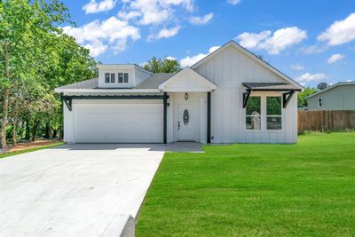 Modern farmhouse style home with a garage and a front lawn | Image 1