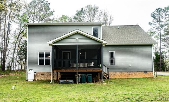 Rear view of house with cooling unit, a sunroom, crawl space, and a yard | Image 35