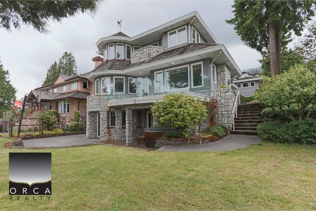 View of front of property with stairway, stone siding, a balcony, and a front yard | Image 39