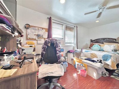 Bedroom featuring cooling unit, wood-type flooring, and ceiling fan | Image 3