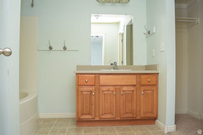 Bathroom with tile patterned floors, vanity, a bathing tub, and baseboards | Image 14