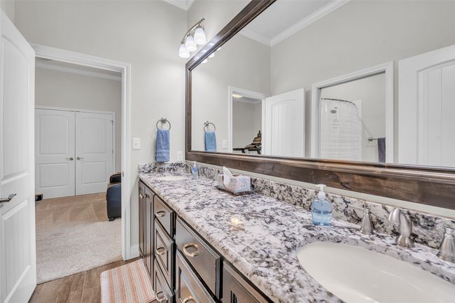 Bathroom with crown molding, double vanity, and wood finished floors | Image 26