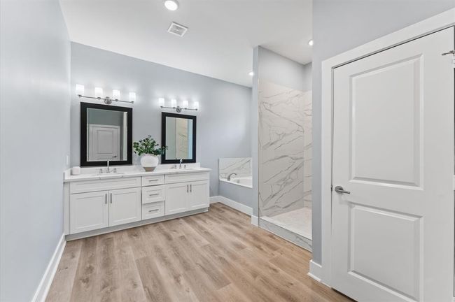 Spa-like bathroom with double sinks, soaking tub, separate shower, and walk-in closet. | Image 21