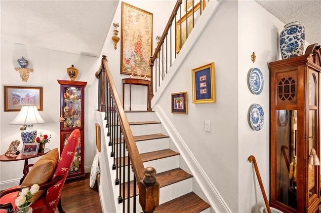 Stairway with wood finished floors and a textured ceiling | Image 10