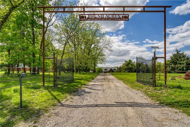 View of street featuring a gated entry, a gate, and gravel driveway | Image 51