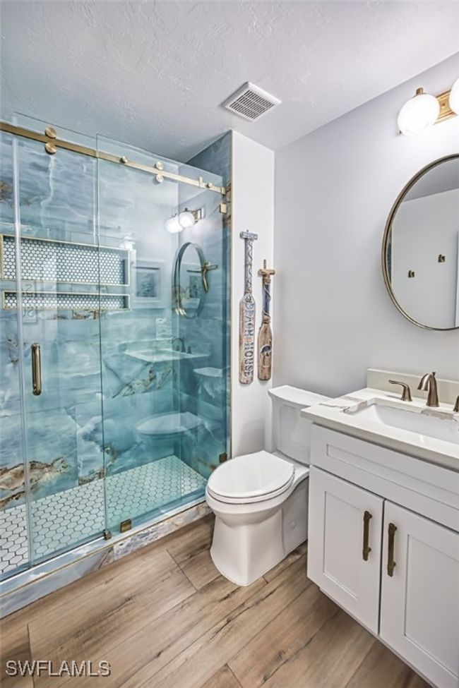 Full bath featuring vanity, wood finished floors, a shower stall, and a textured ceiling | Image 37