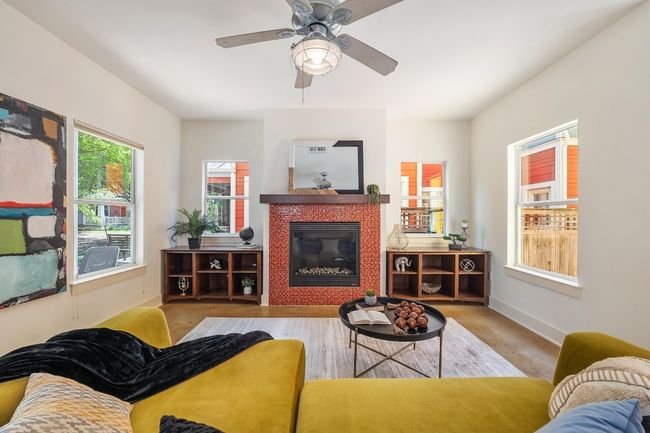 The custom-tiled fireplace in the living room commands attention, its intricate design adding an unexpected layer of personality that becomes the heart of the space | Image 7