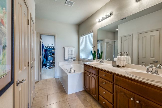 Double sinks, garden soaking tub , enclosed toilet , linen cabinet. | Image 18