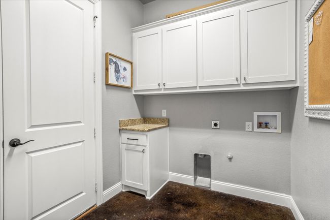 Washroom featuring baseboards, hookup for an electric dryer, cabinet space, hookup for a washing machine, and gas dryer hookup | Image 32