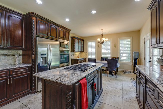 Kitchen with stainless steel appliances, a chandelierover the breakfast area, backsplash, recessed lighting. | Image 14