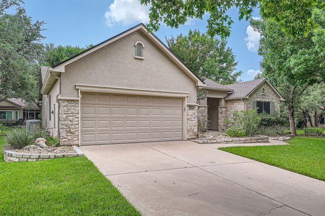 View of front facade featuring stone siding, stucco siding, an attached garage, and concrete driveway | Image 4