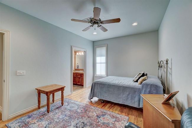 Bedroom with light wood finished floors, ensuite bathroom, baseboards, recessed lighting, and ceiling fan | Image 34