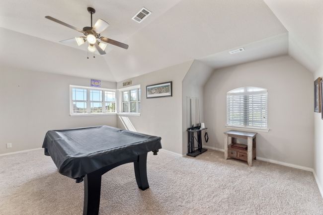 Game room with baseboards, vaulted ceiling, carpet floors, and a ceiling fan | Image 19
