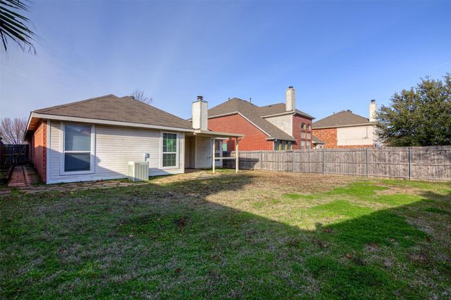 Back of house with central AC unit, a fenced backyard, and a lawn | Image 4