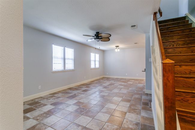 Spare room with ceiling fan and stairway | Image 4