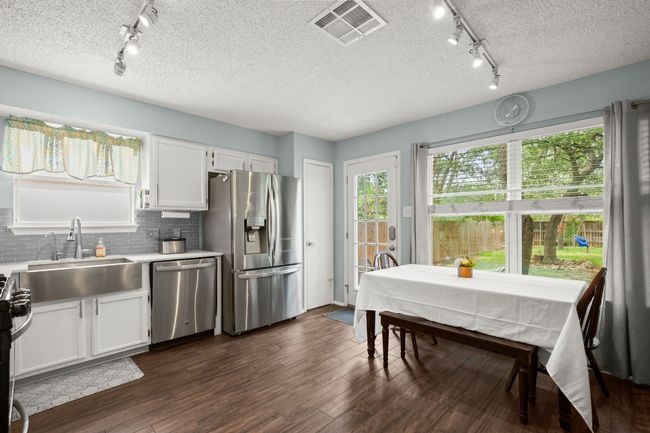 The open-concept kitchen and breakfast area offer a spacious, welcoming layout, making it easy to gather, cook, and enjoy meals together in one comfortable space | Image 13