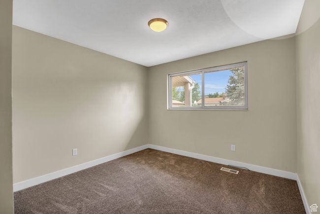 Unfurnished room with dark carpet, baseboards, and visible vents | Image 16