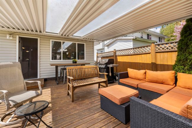 Deck with grilling area, outdoor lounge area, and fence | Image 26