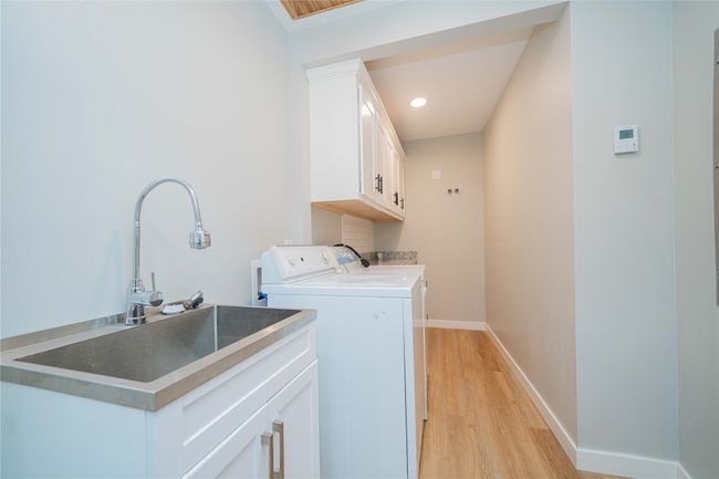Laundry room with cabinet space, washing machine and clothes dryer, light wood-type flooring, and recessed lighting | Image 18