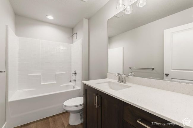 Full bath with wood finished floors, vanity, toilet, and shower / bath combination | Image 9
