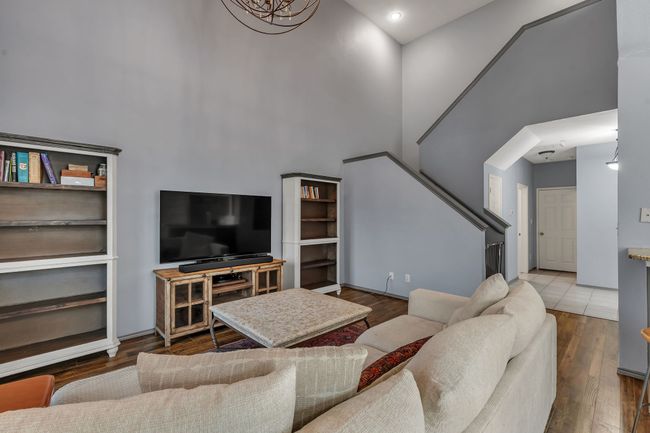 Living area featuring a towering ceiling, stairs, and wood finished floors | Image 15
