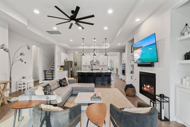 Living area featuring ceiling fan, stairs, a fireplace, recessed lighting, and light wood-type flooring | Image 19