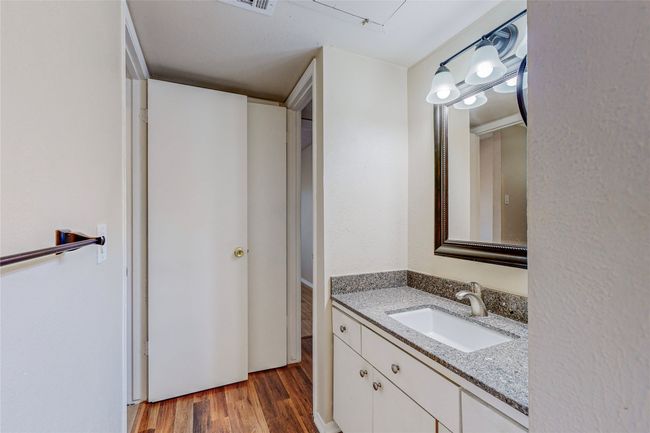 A modern wet room showcasing a vanity unit with a lighted mirror on the wall, designed for comfort and functionality. | Image 21