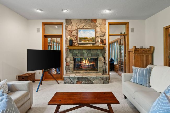 The double sided fireplace is located in the living room and four season room. | Image 8