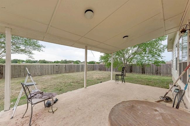 Fenced backyard with a patio area | Image 10