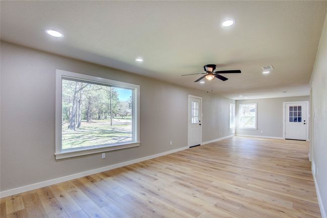 Unfurnished living room with light wood-type flooring, baseboards, visible vents, recessed lighting, and ceiling fan | Image 6