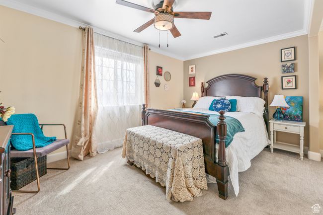 Bedroom featuring carpet floors, crown molding, visible vents, a ceiling fan, and baseboards | Image 24