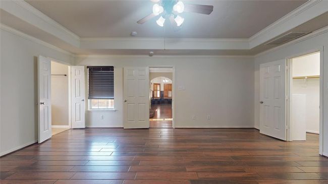 Luxurious primary bedroom featuring elegant tray ceiling and refined crown molding. | Image 20