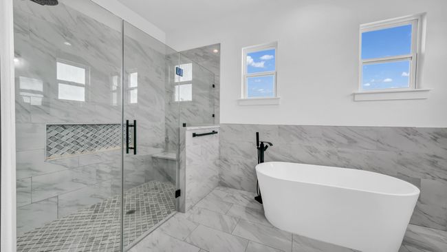 Bathroom featuring a marble finish shower, marble finish floor, a freestanding bath, and wainscoting | Image 25