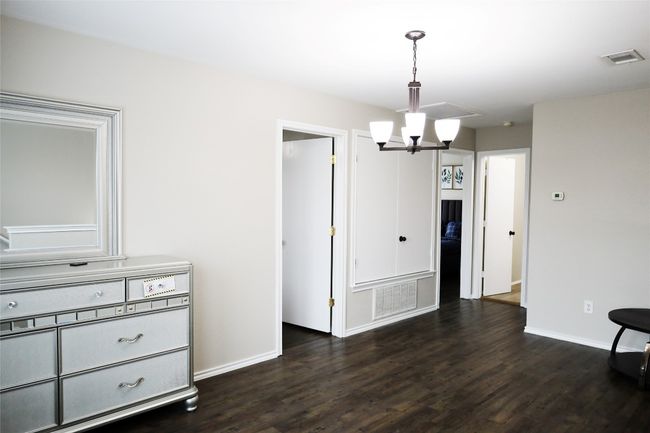 Unfurnished dining area with dark wood-style flooring, baseboards, and a chandelier | Image 7