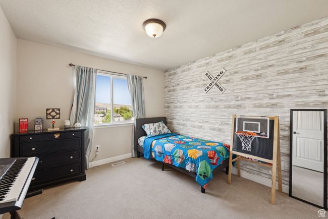 Bedroom with an accent wall, wood walls, and carpet flooring | Image 30