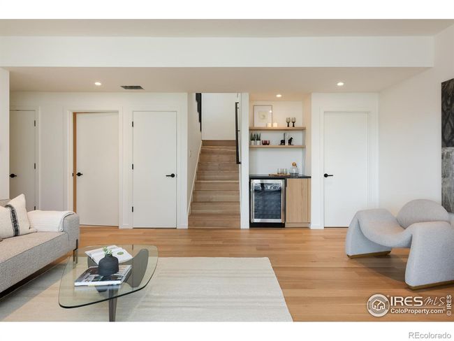 Lower level large family room with bar & beverage fridge, additional soundproofing throughout, secondary laundry room, and a hallway connecting to two bedrooms | Image 28