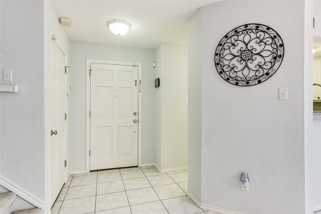 Entryway featuring baseboards, light tile patterned floors, and a textured ceiling | Image 5