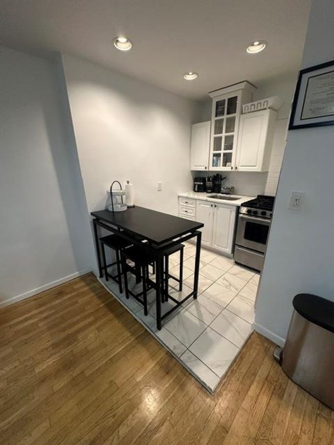 Kitchen with stainless steel range with gas cooktop, a sink, light wood-type flooring, white cabinets, and recessed lighting | Image 4