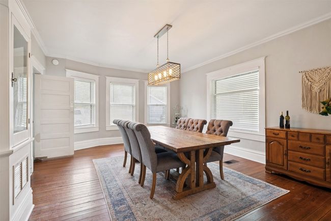 Dining area featuring a chandelier, dark wood-type flooring, and crown molding | Image 9