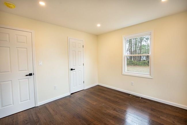 Unfurnished bedroom featuring baseboards, dark wood finished floors, visible vents, and recessed lighting | Image 14